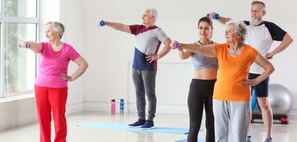 Elderly people training with instructor in gym