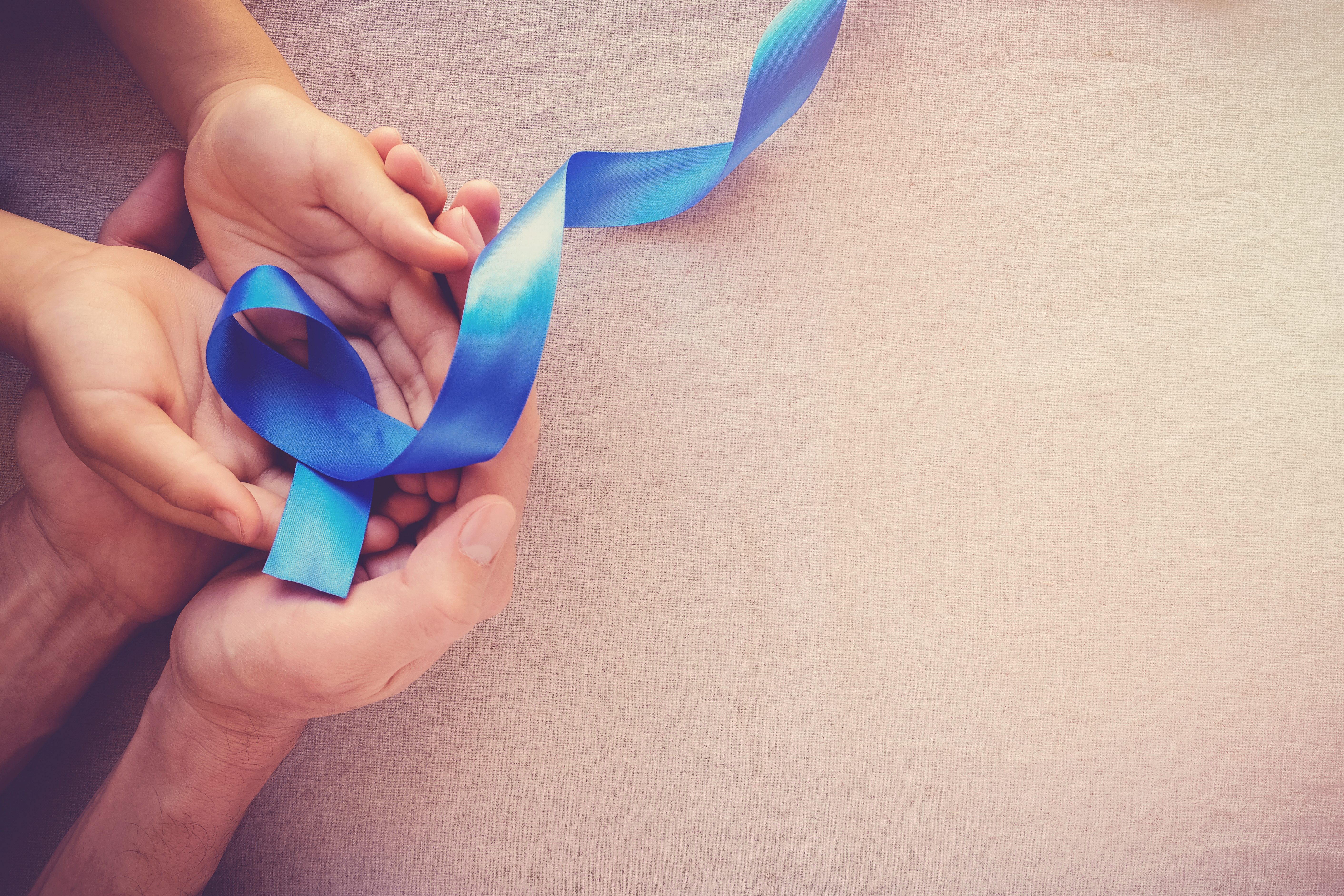 adult and child hands holding Blue ribbon, Colon Cancer, Colorectal Cancer, Child Abuse awareness, world diabetes day