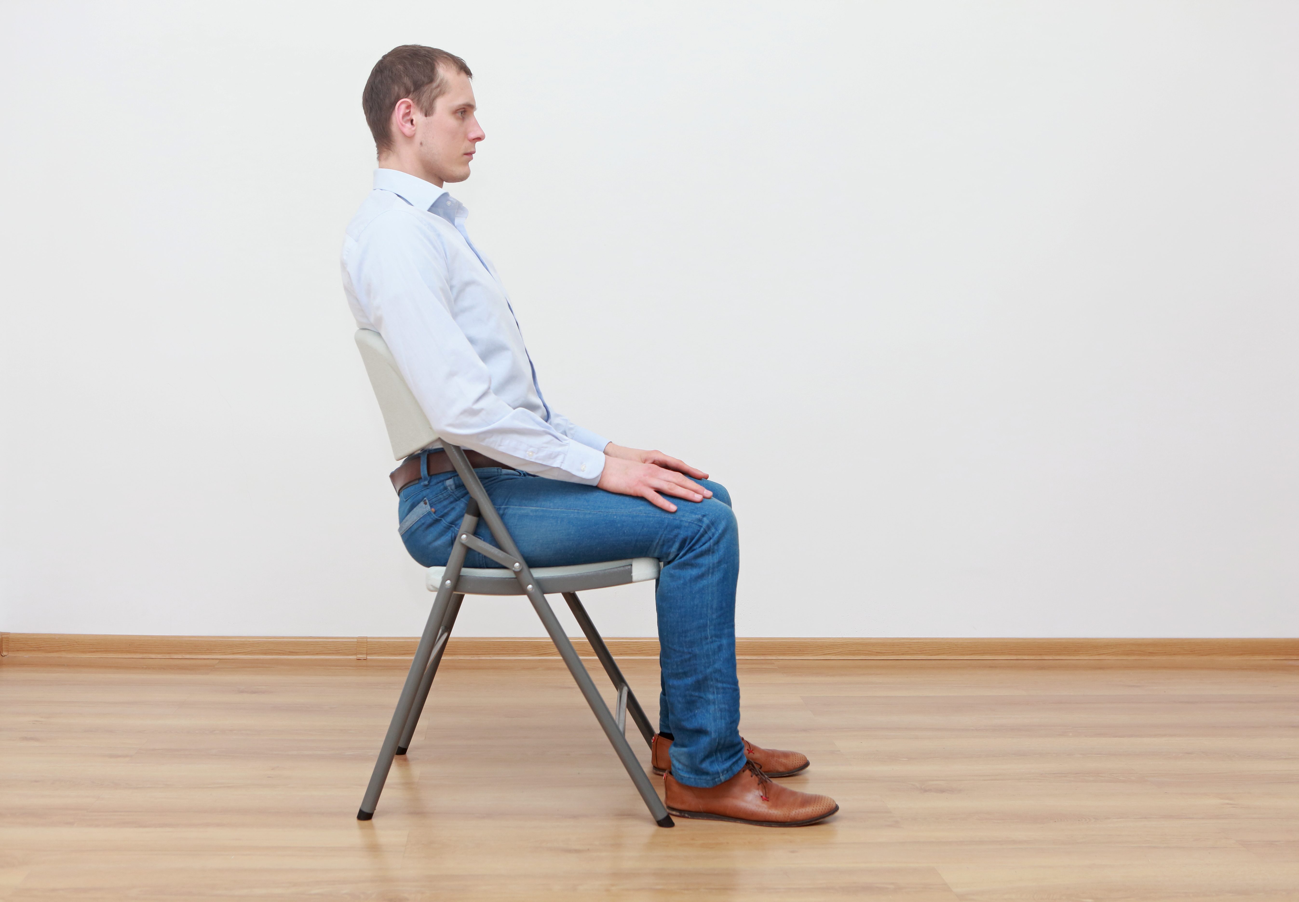 caucasian man sitting on the  chair in correct  posture