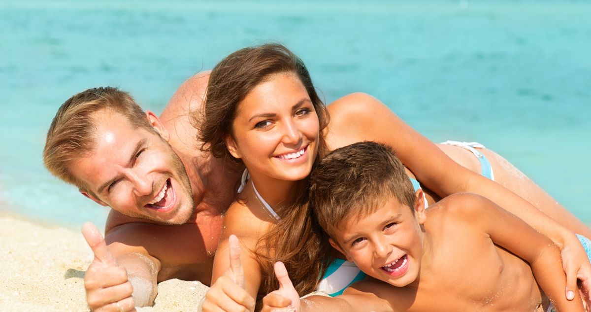 Happy Young Family with Little Kid Having Fun at the Beach